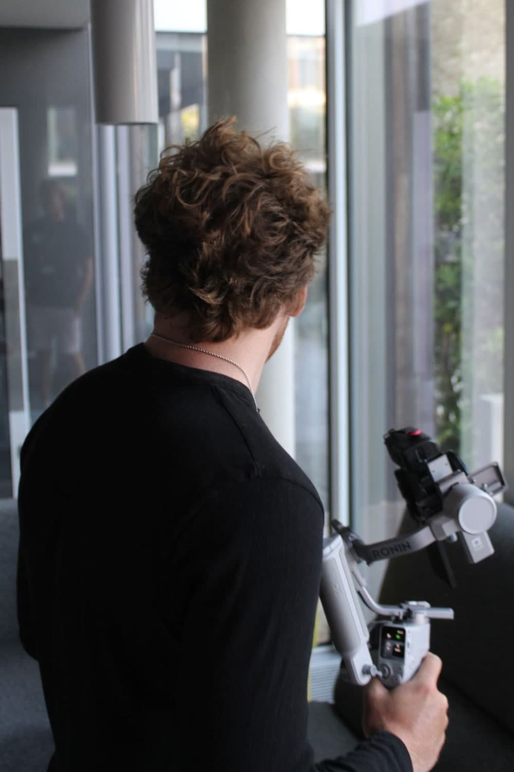 Over-the-shoulder view of a gimbal operator lining up an interior shot